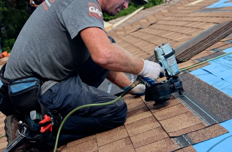 roofer-installing-asphalt-shingles-during-roof-replacement-on-a-michigan-home